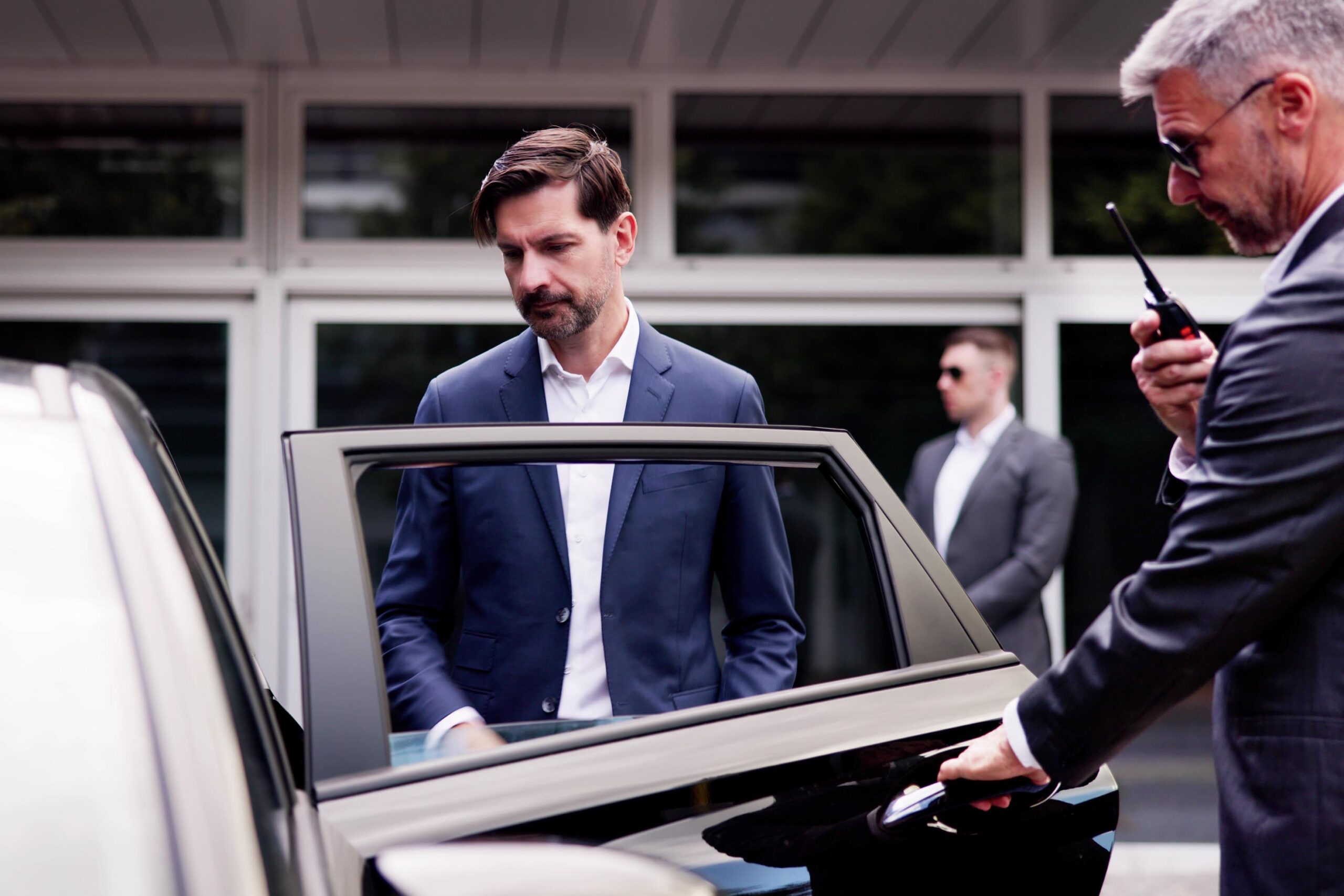 High-End Executive Vehicle Escort: VIP Protection Service Ensures Safety of Businessman with Handsome Bodyguards and Professional Security Measures.